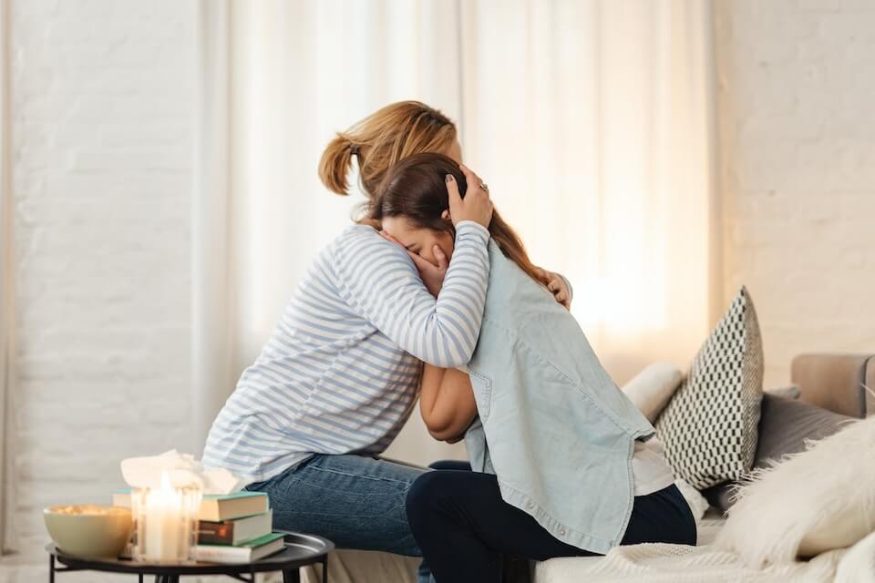 mother comforting crying daughter