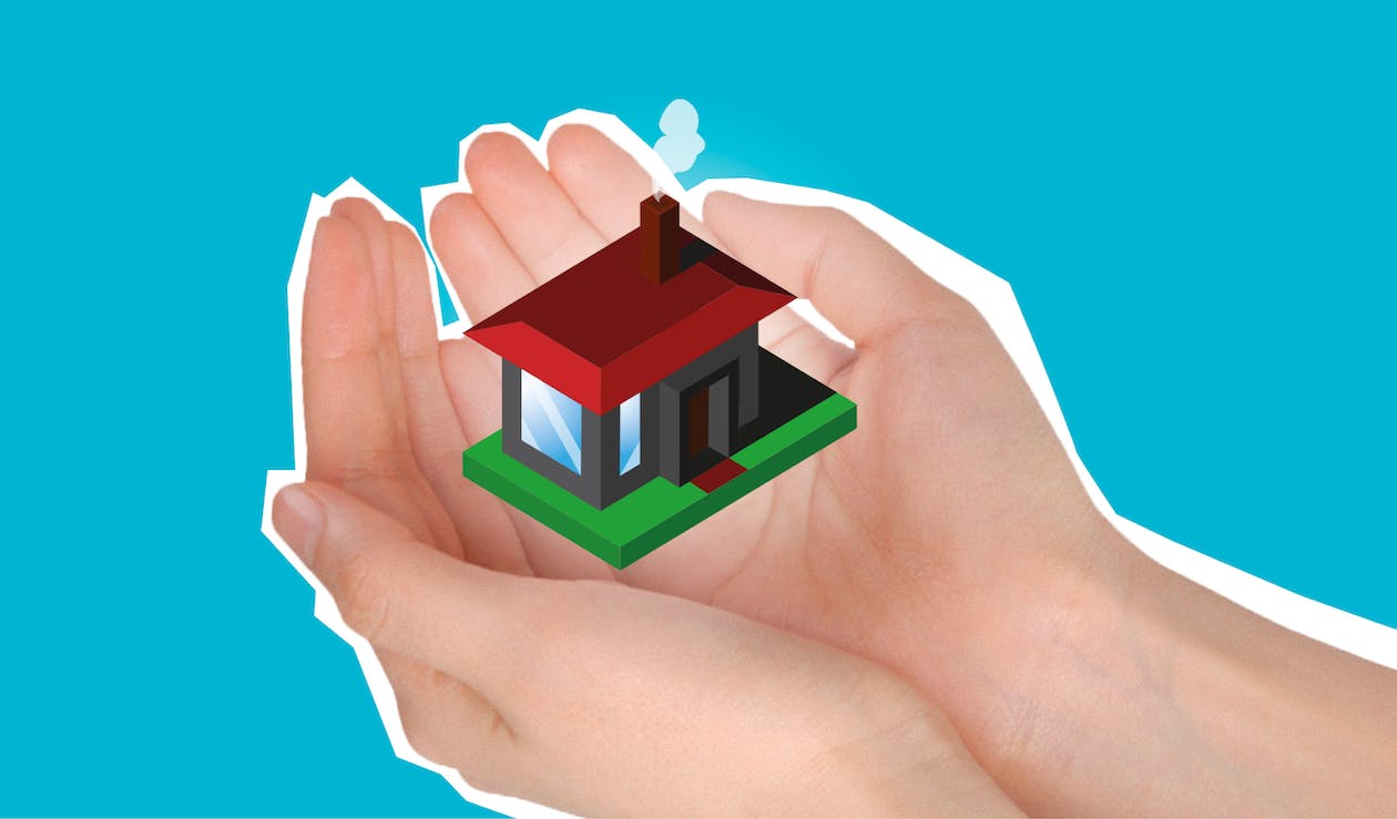 pair of hands holding graphic of model home