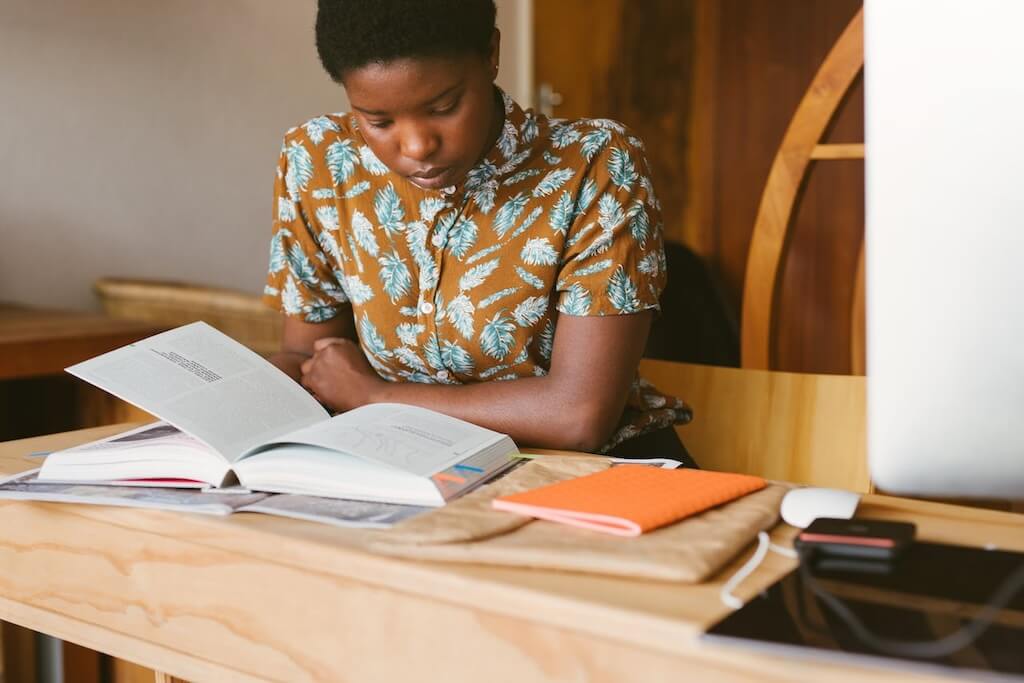 woman sitting at desk studying book