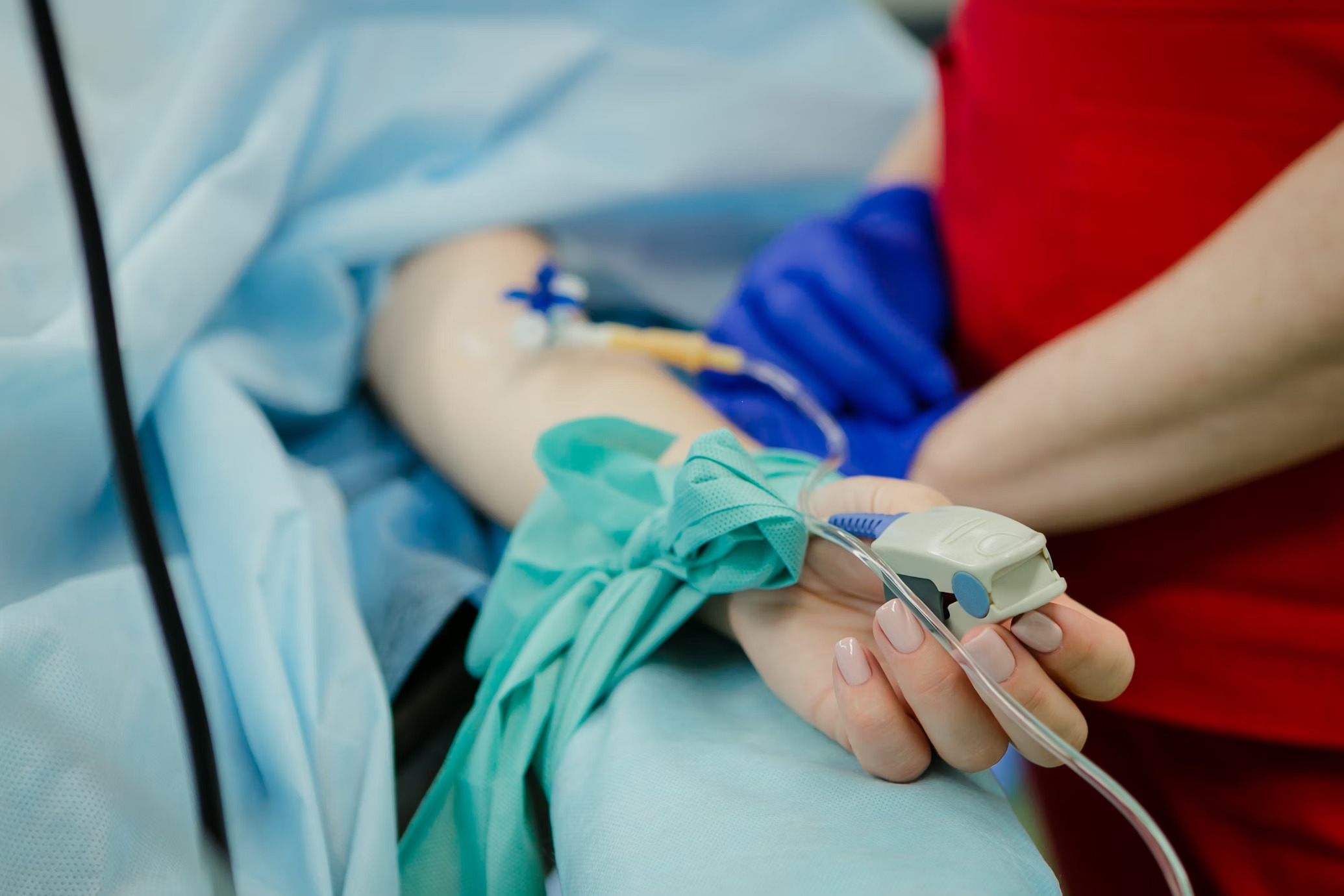 arm of person lying on hospital bed with IV
