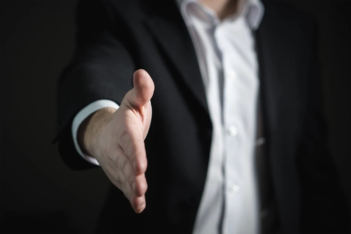 man in suit holding out hand for a handshake