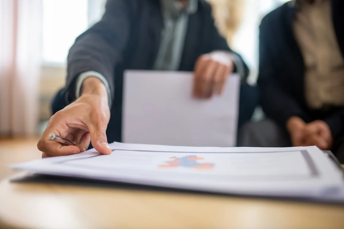 person in suit reaching for a document