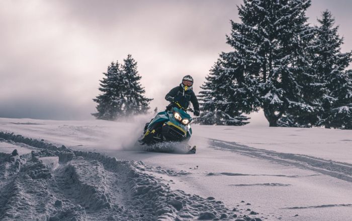 person riding snowmobile through deep snow