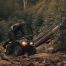 man in forest climbing aboard his all terrain vehicle