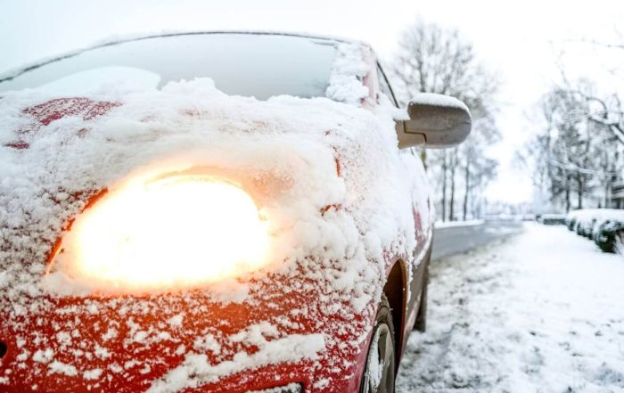 red sedan covered in snow