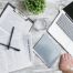 home insurance policy paperwork next to laptop and notebook on desk