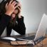 A woman holding her head in her hands looking distraught