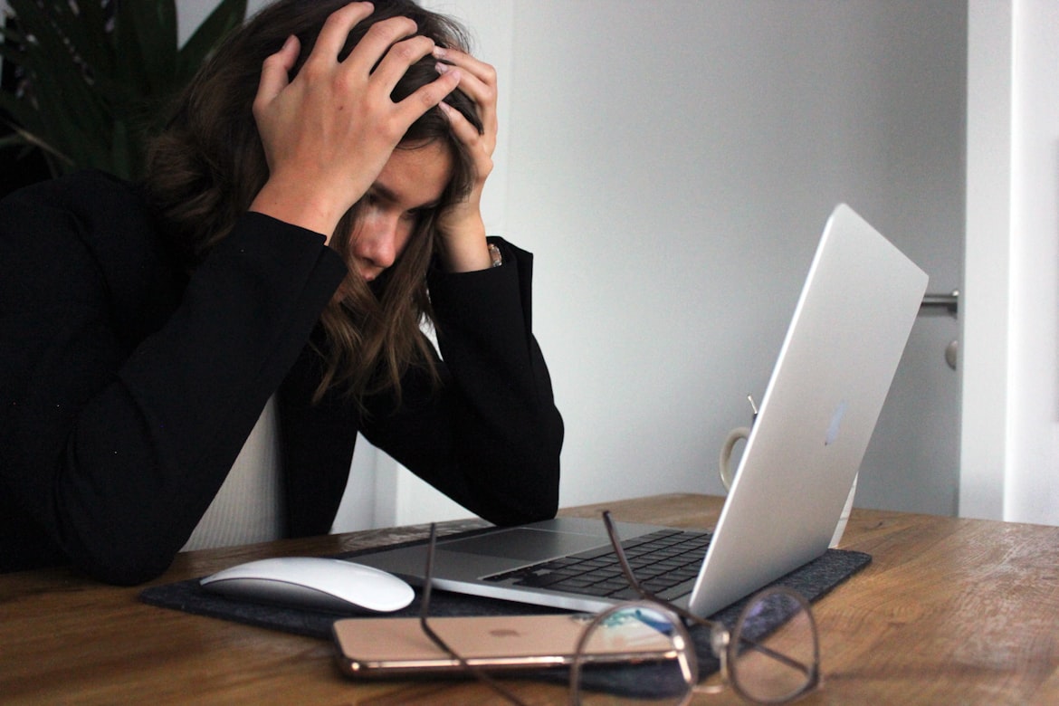 A woman holding her head in her hands looking distraught