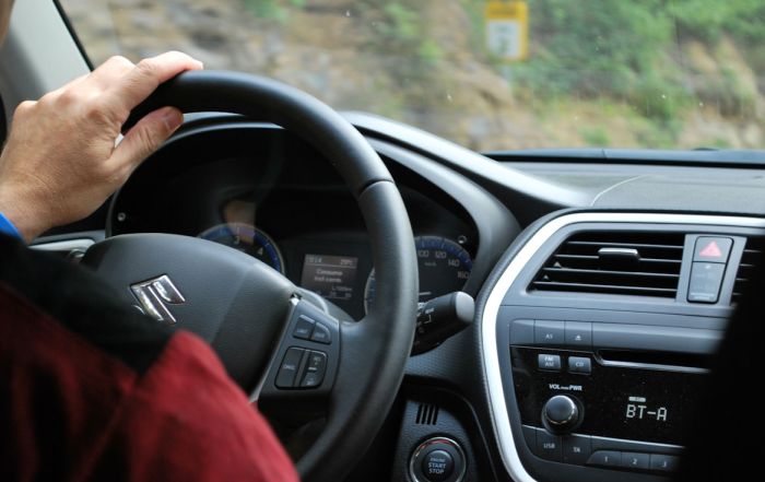 A person sitting behind the wheel and driving their automatic vehicle
