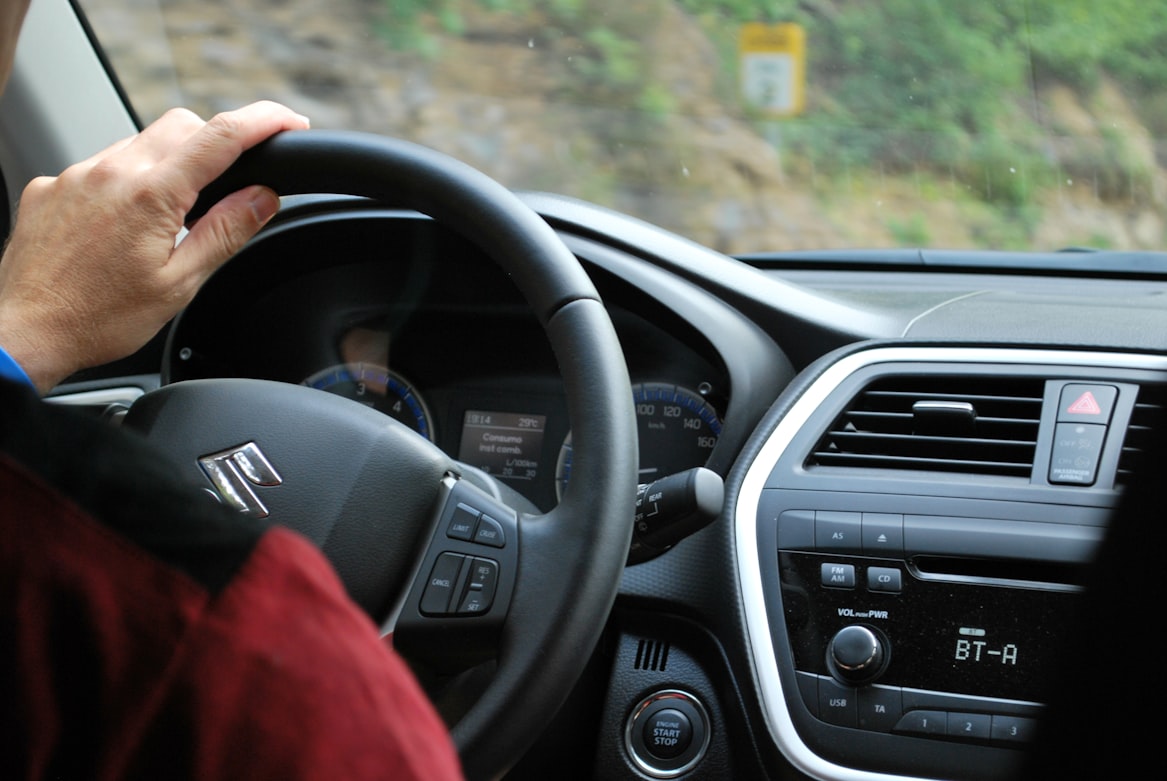 A person sitting behind the wheel and driving their automatic vehicle