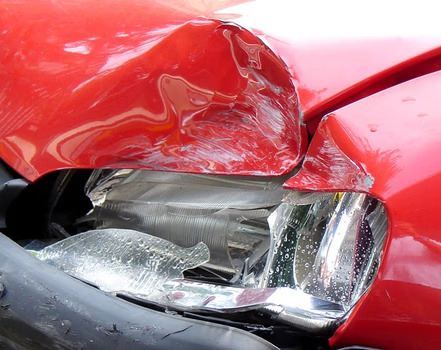 The damaged front end of a red car