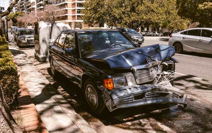 A car left heavily damaged on the side of the road