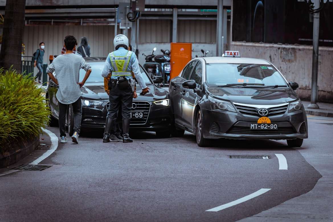 Post8 A police officer and civilian standing at the scene of two cars in a car accident