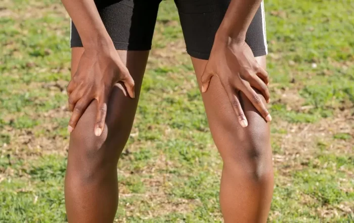 An athlete grasping his knees in pain